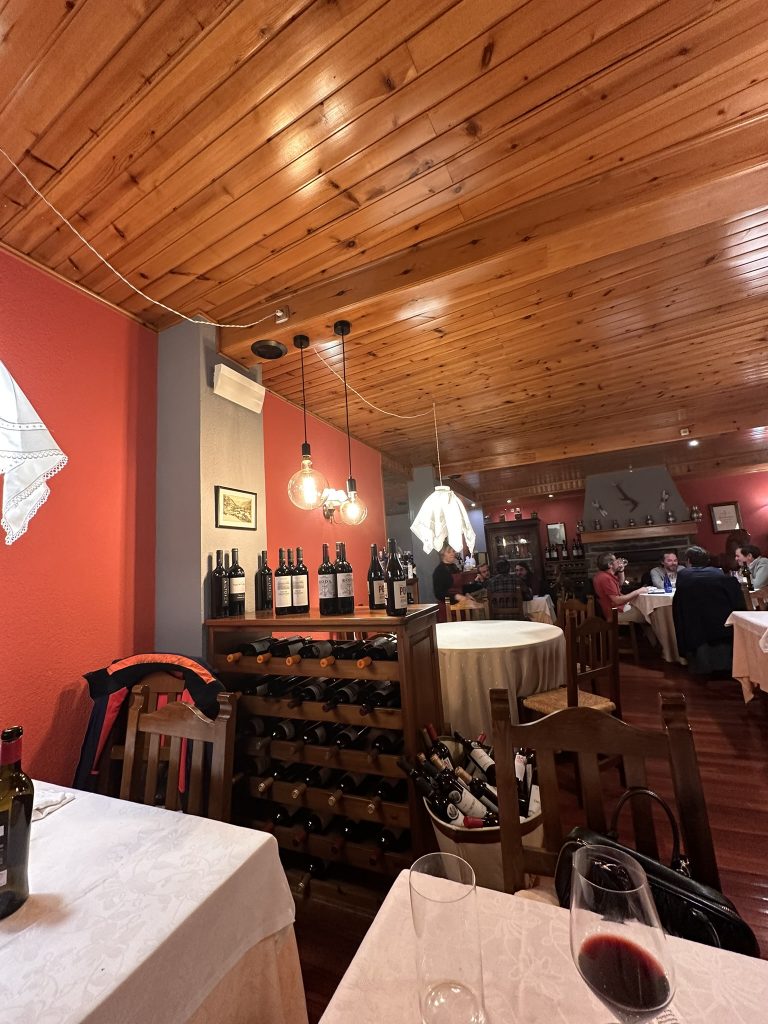 Interior Restaurante El Niu Escunhau, chimenea mesas madera vigas, ambiente rústico Valle de Aran