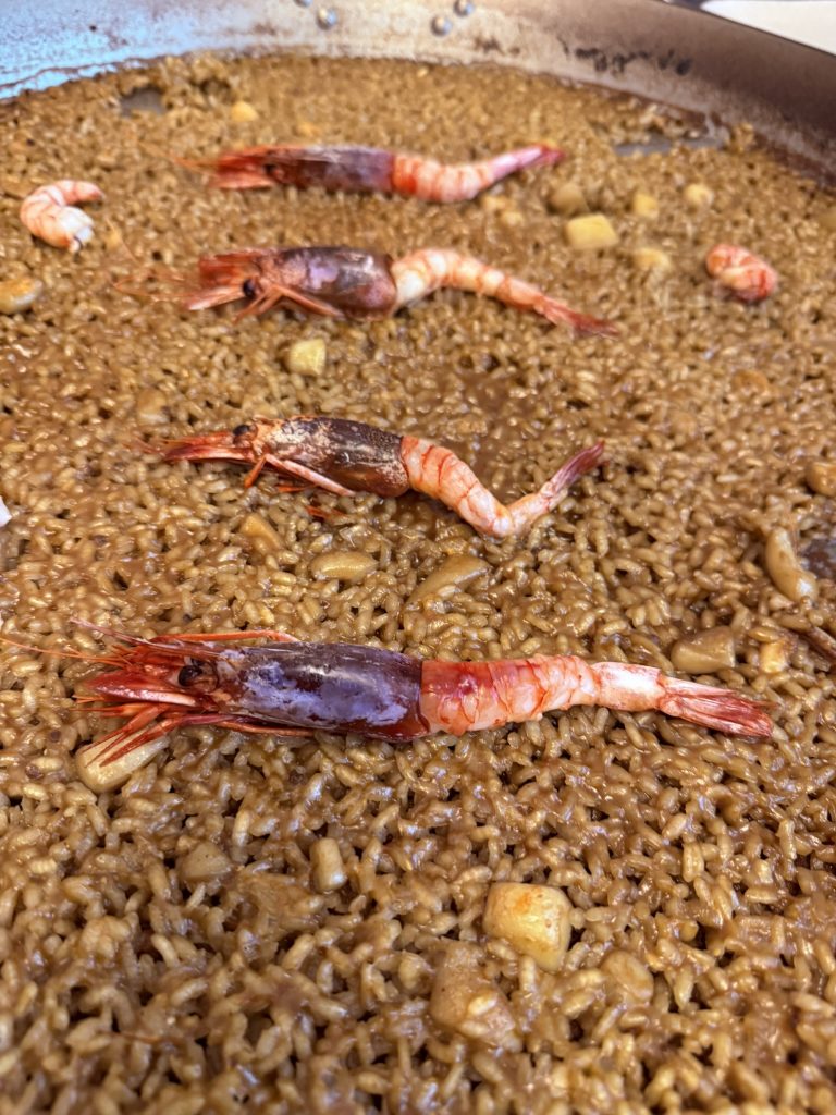 Primer plano de arroz del Senyoret con gamba roja, servido en paella en restaurante El Portón de Sorní de Valencia