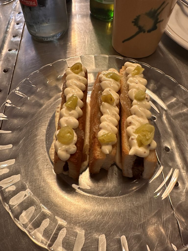Bikini de jarrete de ternera con queso mahón, mostaza, cebolla caramelizada y piparras dulces