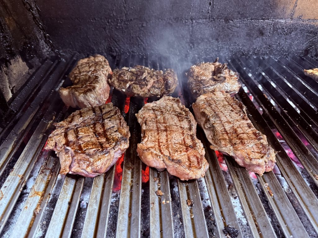 Bife de chorizo en la parrilla con fuego vivo en el Asador Viejo Barrio, Benimaclet