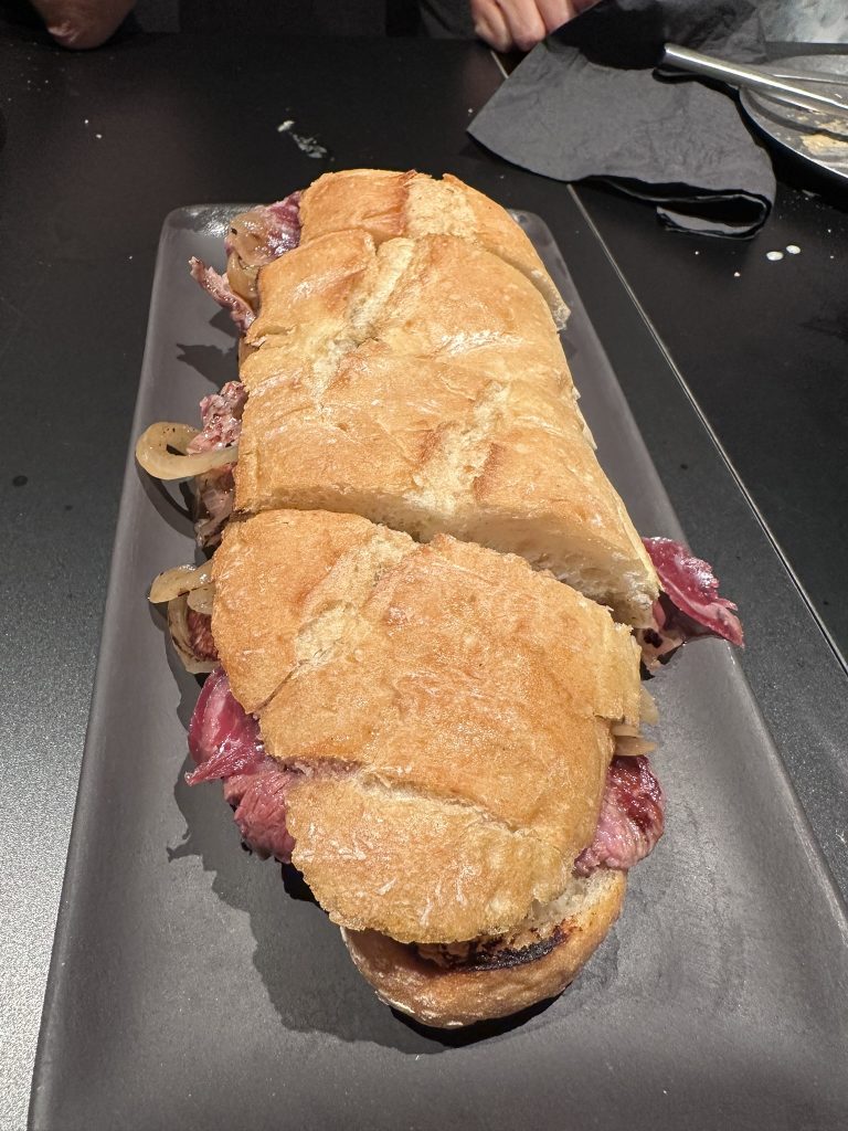 Bocadillo de brascada con ternera jugosa y jamón de bellota sobre pan artesanal tostado