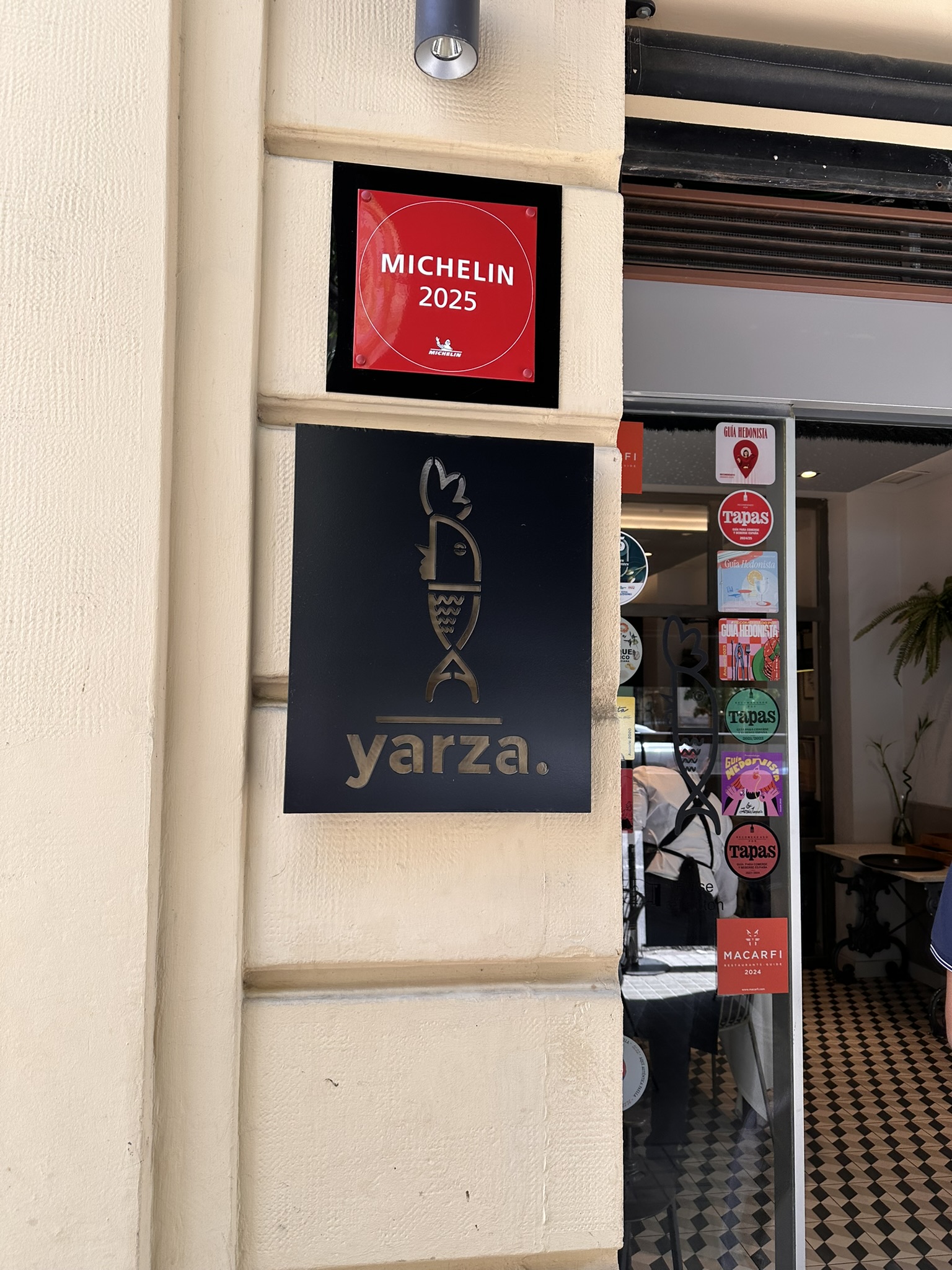 Fachada del Restaurante Yarza mostrando el logo del restaurante y el cartel de la Guía Michelin 2025
