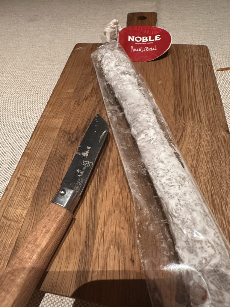 Fuet de chocolate con textura rica y apariencia de embutido, mostrando su superficie cubierta de cacao