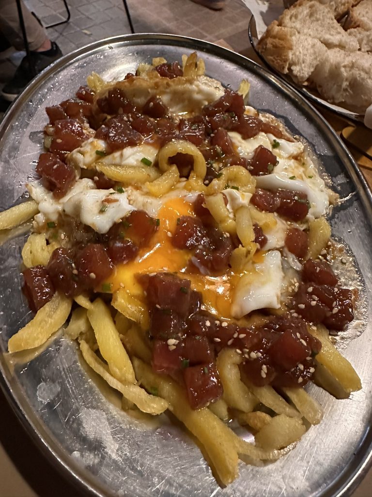 Huevos rotos con atún rojo picante, plato tradicional con un toque moderno