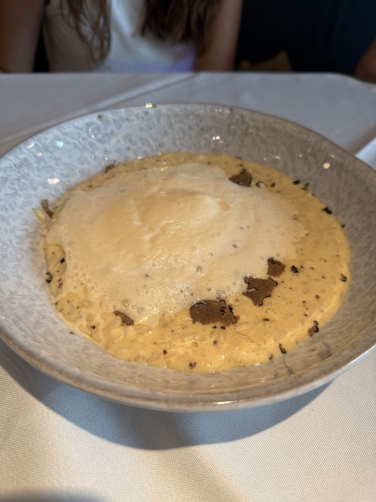 Risotto cremoso con queso pecorino, pimienta negra y láminas de trufa fresca