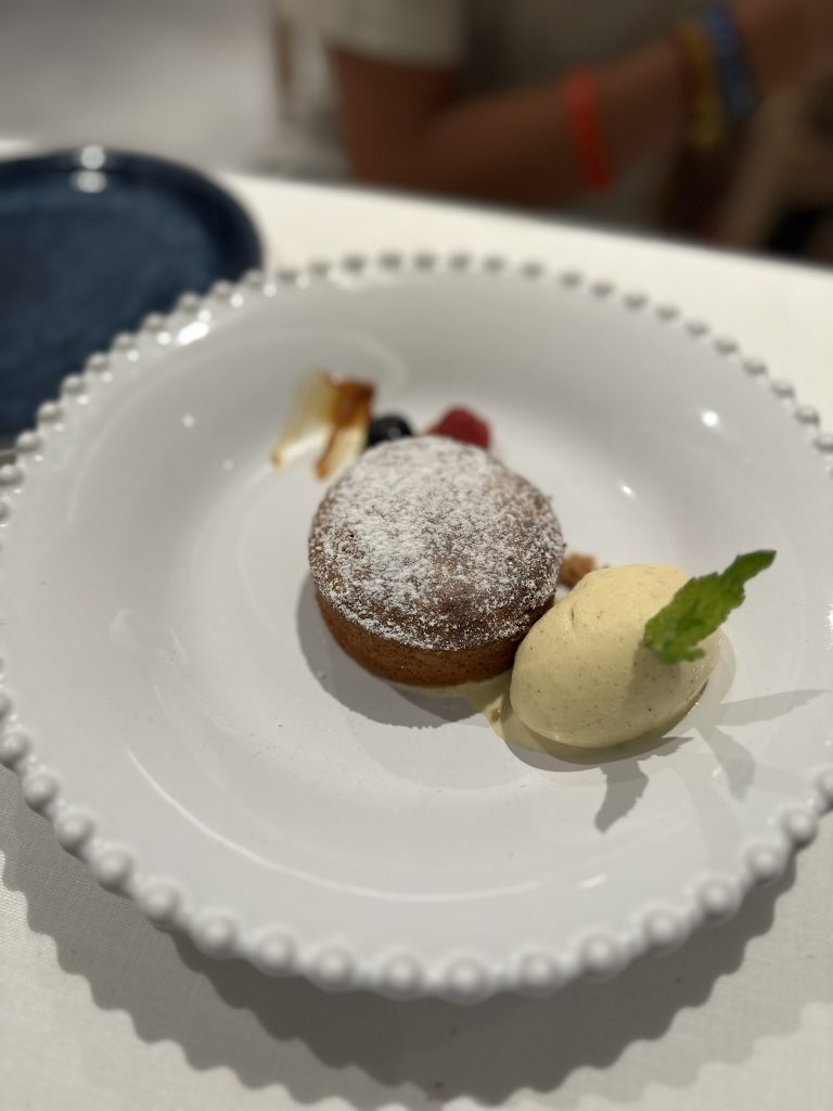 Coulant de chocolate fundente con un centro líquido de chocolate oscuro, acompañado de una bola de helado de vainilla.
