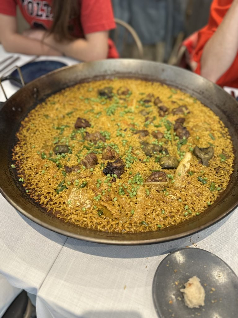 Paella valenciana con costillas ibéricas, arroz en su punto y variedad de verduras de temporada.