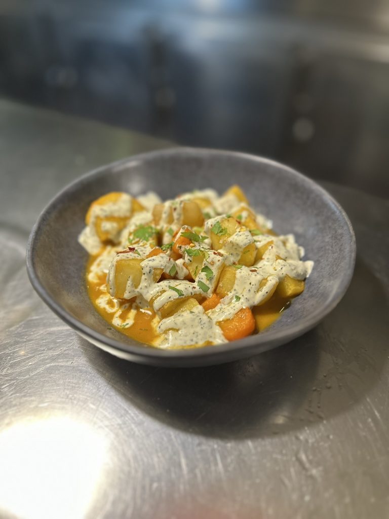 Patatas bravas estilo marroquí con especias y salsas caseras servidas en Boucan Winebar