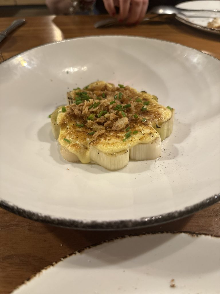 Puerros asados con salsa holandesa trufada, servidos en Basea Restaurante en Valencia