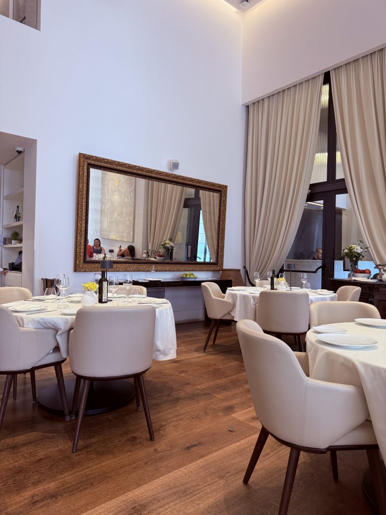 Vista del interior de Milos Restaurant en Atenas, con techos altos, luz natural y decoración elegante