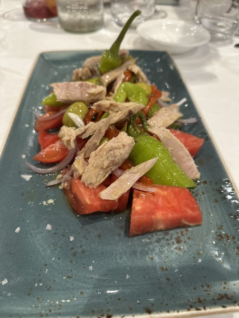 Plato de tomate rosa con ventresca de bonito, pimiento asado, cebolla morada, piparras dulces y aceitunas en Restaurante El Pincelín de Almansa.