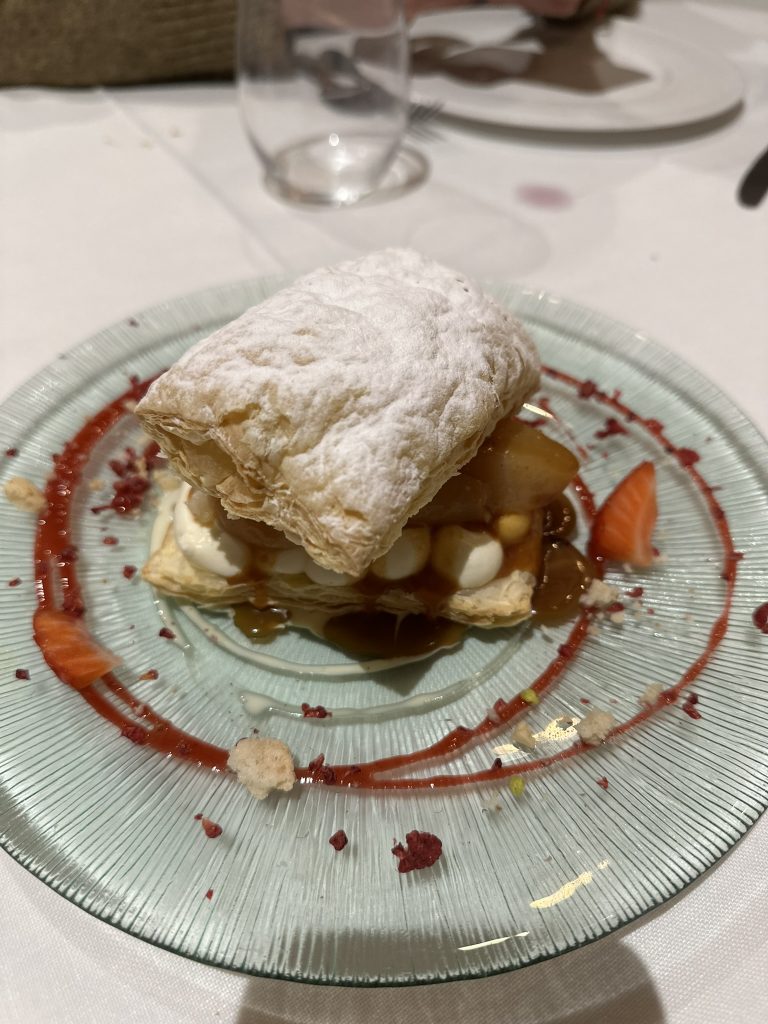 Primer plano de una porción de hojaldre de peras caramelizadas con crema ligera y toffee, un postre que te conquistará desde el primer bocado.