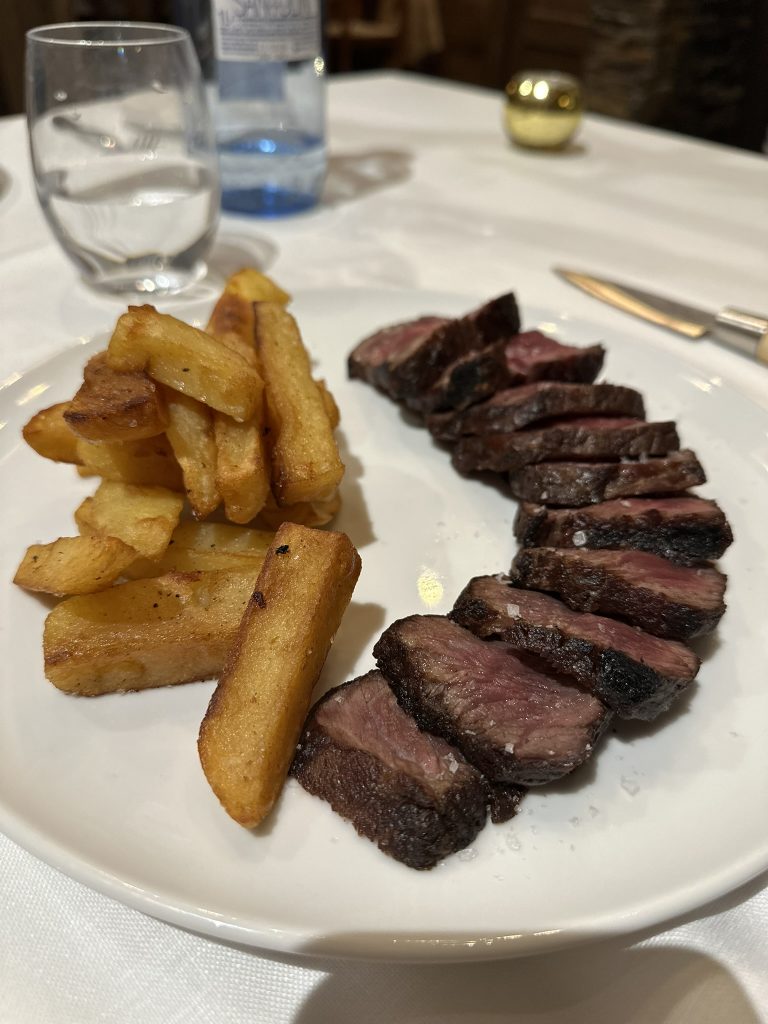 Un plato de lomo de vaca a la brasa con salteado de patatas, chalotas y salsa bearnesa, una delicia de la cocina de montaña.